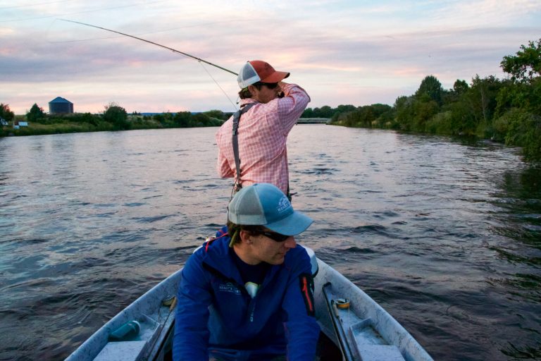 2 man fly fishing out of a boat