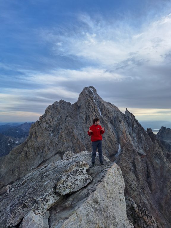 Man posing on top of a mountain