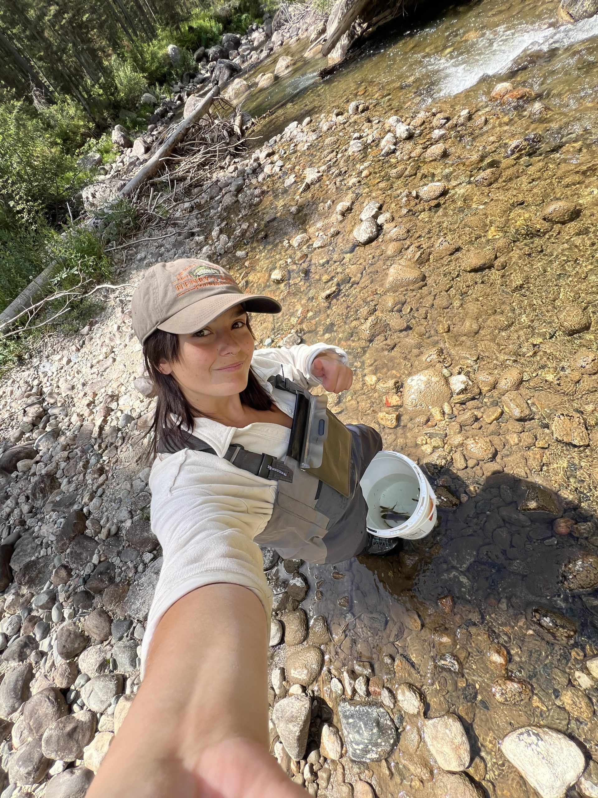 Selfie of woman in shallow water with bucket
