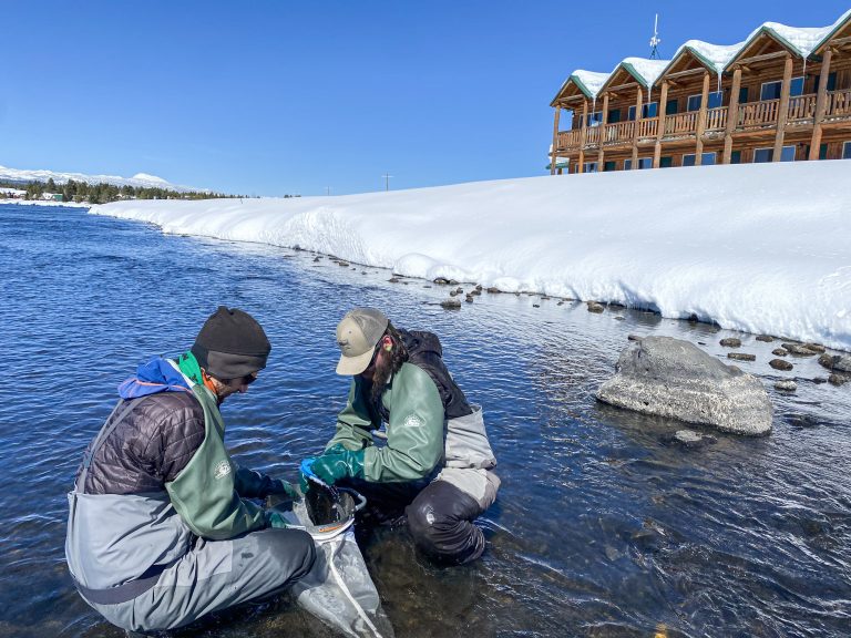 2 people in gear taking water samples