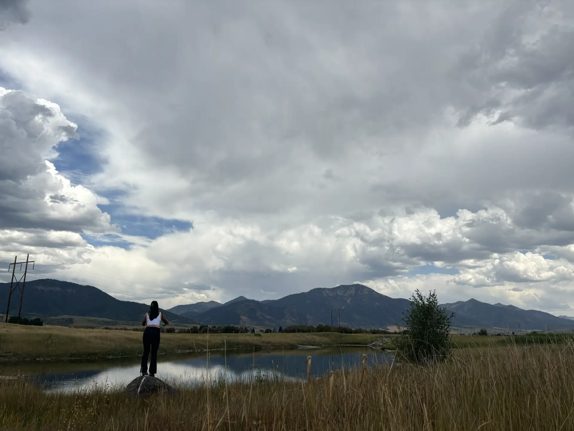 Woman in river near mountains